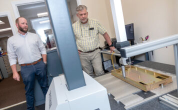 PRECISION MEASUREMENTS: Jade Manufacturing Co. Vice President Chris Burch, left, and Quality Manager Ronald Olf with the company’s Spectrum coordinate measuring machine, which uses computer-controlled probes to verify three-dimensional measurements. PBN PHOTO/MICHAEL SALERNO