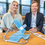 BABY STEPS: Maey Petrie, left, director of programs and business developent at New England Medical Innovation Center, and Robert Cooper, SmölTap CEO, with the product designed to hold infants still while undergoing a spinal tap. It will launch this fall.  PBN PHOTO/MICHAEL SALERNO