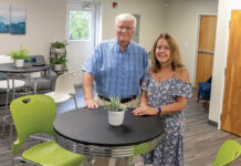 TRANSFORMED SPACE: David MacDonald, owner of CoWork Cumberland LLC, meets with office manager Marybeth Young in the cafe space. PBN PHOTO/MICHAEL SALERNO
