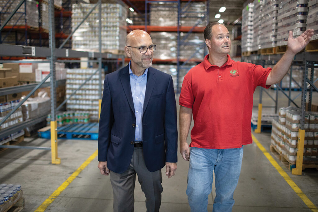 WAREHOUSE WALK: Rhode Island Community Food Bank CEO Andrew Schiff, left, and Director of Operations Jack Russell peruse the nonprofit’s food warehouse in Providence. PBN PHOTO/ RUPERT WHITELEY