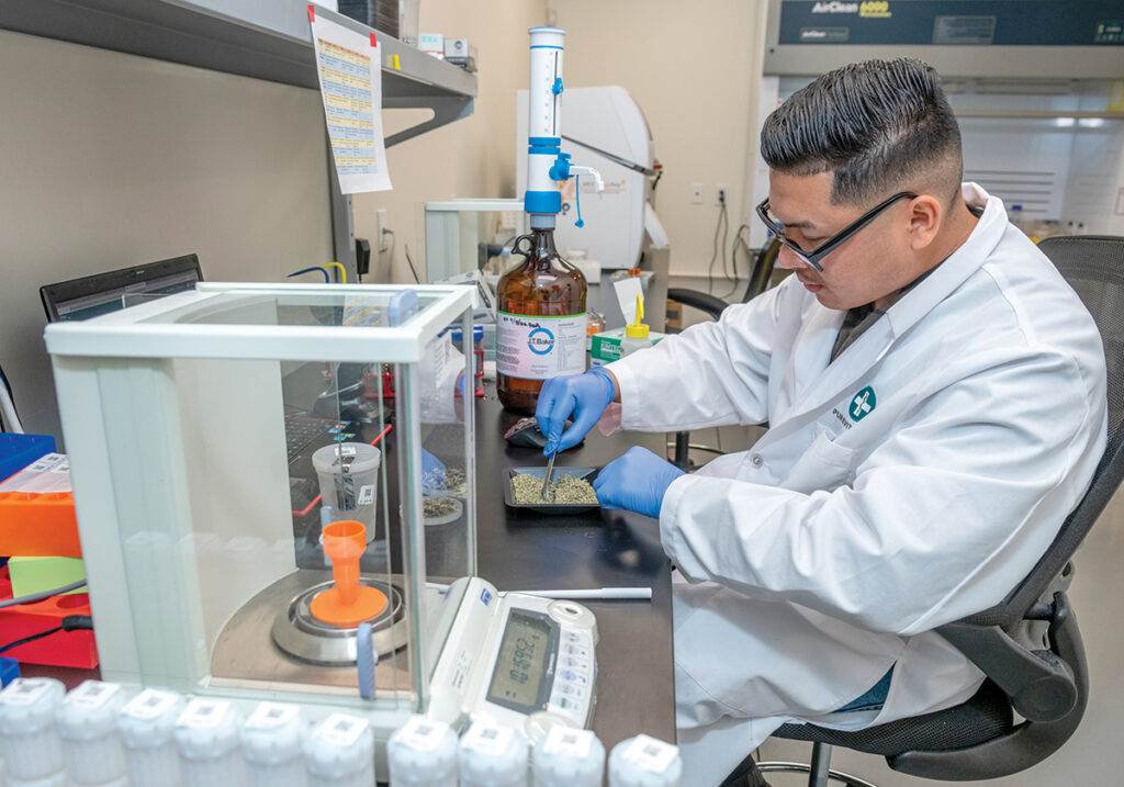 QUALITY WORK: Analyst Byron Acevedo processes samples of cannabis from cultivation centers at the PureVita Labs LLC facility in Warwick. Observers expect the sector to need more personnel with a scientific background as the Rhode Island cannabis industry matures.  PBN PHOTO/MICHAEL SALERNO