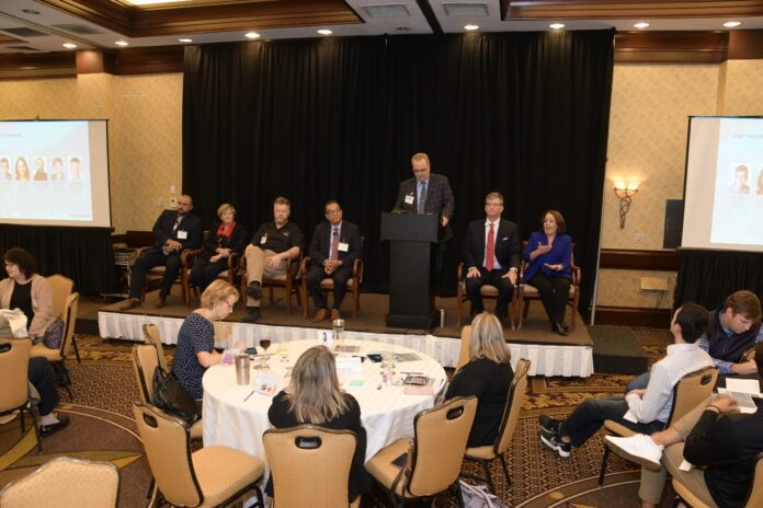 LISA SHORR, far right, Secure Future Tech Solutions vice president, speaks during the PBN Cybersecurity Summit at the Crowne Plaza Providence-Warwick on Thursday afternoon. She is joined during one of the panel discussions by, from left, Jason Albuquerque, Envision Technology Advisors LLC chief operating officer; Linn F. Freedman, certified information privacy professional and U.S. chair of the data privacy and cybersecurity team at Robinson & Cole LLP; Doug White, professor of cybersecurity and networking at Roger Williams University; Shakour A. Aubuzneid, professor of cybersecurity and networking and incoming program director at RWU; and Eric Shorr, Secure Future Tech president. Standing is PBN Editor Michael Mello. / PBN PHOTO/MIKE SKORSKI