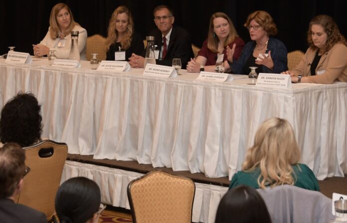 DR. CLAIRE LEVESQUE, second from right, chief medical officer for commercial products at Point 32Health, the parent company of Tufts Health Plan and Harvard Pilgrim Health Care, speaks during one of two panel discussions at PBN's Fall Health Care Summit on Thursday at Crowne Plaza Providence-Warwick. Also on the panel are, from left, Dr. Kirsten Anderson, medical director at CVS Health Corp./Aetna; Dr. Louanne Giangreco, senior medical director at Blue Cross & Blue Shield of Rhode Island; Dr. Peter Hollmann, chief medical officer at Brown Medicine; Dr. Alexis Kearney, consultant medical director for Project Firstline RI, Center for Acute Infectious Disease Epidemiology, R.I. Department of Health; and Dr. Jennifer Nuzzo, director of the Pandemic Centr at Brown University's School of Public Health. PBN PHOTO/MIKE SKORSKI