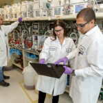 LAB WORK: From left, Amgen Rhode Island scientists George Boras, Natalie Kieon and Bishouy Sharoubim join together in a laboratory inside the West Greenwich manufacturing facility.  PBN PHOTO/TRACY JENKINS