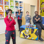 WAKANDA FOREVER: From left, Bryony Bouyer, Hasbro Inc.’s senior vice president of diversity and inclusion and multicultural strategy; Olga Lowe, manager of global brand development and marketing; Tayla Reo, product development manager; and Phil Johnston, senior creative writer, pose with arms crossed in a salute made famous in Marvel Entertainment LLC’s Universe’s “Black Panther” movie.  PBN PHOTO/DAVID HANSEN