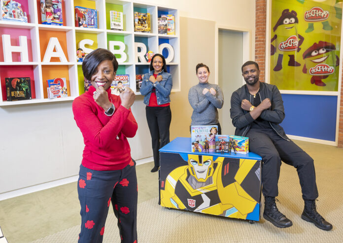 WAKANDA FOREVER: From left, Bryony Bouyer, Hasbro Inc.’s senior vice president of diversity and inclusion and multicultural strategy; Olga Lowe, manager of global brand development and marketing; Tayla Reo, product development manager; and Phil Johnston, senior creative writer, pose with arms crossed in a salute made famous in Marvel Entertainment LLC’s Universe’s “Black Panther” movie.  PBN PHOTO/DAVID HANSEN