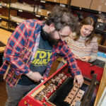 WHIMSICAL PRODUCTS: Katy Westscott, CEO of Katrinkles Inc. in Providence, which makes buttons and tools for crafters, goes over some of the company’s products with production technician Brandon Amorin. PBN PHOTO/TRACY JENKINS