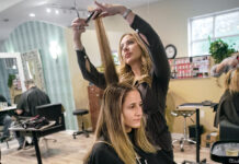 GOING UP: Michelle Murphy, owner of Roots Hair Salon LLC in Cranston, works on Talias Oakane of ­Cranston. Murphy says she may have to raise the rent she charges her stylists, who recently raised their prices due to the increased cost of products, because her monthly payment to rent the building space for the salon recently increased. PBN PHOTO/MICHAEL SALERNO