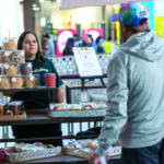 POP-UP BAKERY: Thrive Cakery LLC owner Jasmine Mendez speaks with John Shaw of Cumberland about her products, which she will be offering through a pop-up kiosk on the second floor of the Providence Place mall through the new year. PBN PHOTO/MICHAEL SALERNO