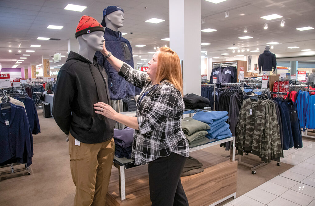 STRAIGHTEN UP: Maryann McCann, assistant manager of the men’s department at Boscov’s Inc. in the Providence Place mall, straightens up a mannequin display. PBN PHOTO/MICHAEL SALERNO