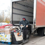 HEAVY LIFTING: Cliff Moniz, a driver/warehouse worker at the We Share Hope food pantry and market in East Providence, unloads food ­donations.  PBN FILE PHOTO/­MICHAEL SALERNO