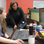 RECRUITING ­ASSISTANCE: Dawn Apajee, right, owner of staff recruiting agency City Personnel Inc., works with senior recruiter Megan Atkins at her office in Providence. PBN PHOTO/­ELIZABETH GRAHAM