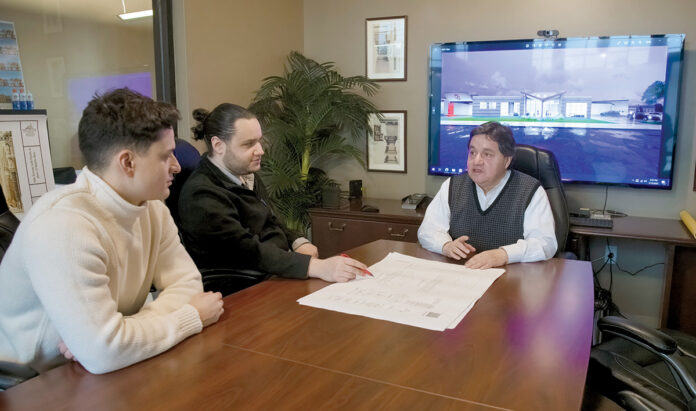 FAMILY MEETING: Andrew Torrado, left, and Luis C. Torrado, second from left, speak with their father, Luis A. Torrado, president of L. A. Torrado Architects Inc. in Providence. Torrado’s sons are project managers at the company. PBN PHOTO/MICHAEL SALERNO