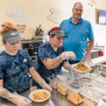 TROPICAL FLAVORS: Team members Julie Cox, left, and Blanca Goetz prepare poké bowls while co-owner Jim Way observes at Island Fin Poké Co. in Smithfield. PBN PHOTO/TRACY JENKINS