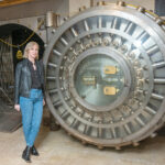 CONVERSATION STARTER:  Compass Real Estate agent Kira Greene stands outside the vault that comes with a former Pawtucket bank she is marketing as a candidate for residential conversion.  PBN FILE PHOTO/­MICHAEL SALERNO