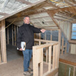 CLIMATE CONTROL: Mark Horan, owner of Horan Building Co., shows the energy-saving features of a home he is building in Newport, including closed cell foam insulation, which is used on the walls to make the attic space comfortable in winter and summer. PBN PHOTO/ MICHAEL SALERNO