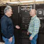 DATA CENTER: Ocean State Job Lot Chief Information Officer Hisham Aharon, left, and Chief Financial Officer John Conforti inspect the computer servers that power the retailer’s technology, including the artificial intelligence software it uses.  PBN PHOTO/TRACY JENKINS
